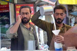 A street vendor sells buttermilk (lassi) to customers to beat the summer heat as the mercury rises in the city