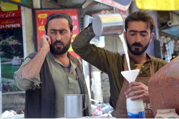 A street vendor sells buttermilk (lassi) to customers to beat the summer heat as the mercury rises in the city