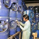 A shopkeeper displays solar water coolers as demand rises during the summer season