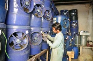 A shopkeeper displays solar water coolers as demand rises during the summer season