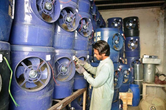 A shopkeeper displays solar water coolers as demand rises during the summer season