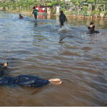 Children take bath in the stagnant water due to leakage in the line of the water supply near Karachi University