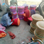 A laborer sits in the shade near Shahdara Road making a set of wooden chairs made from bamboo sticks