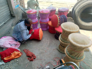 A laborer sits in the shade near Shahdara Road making a set of wooden chairs made from bamboo sticks