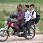 Students on their way to school on motorcycle as educational institutions reopen after a one-day closure due to Indian airstrikes