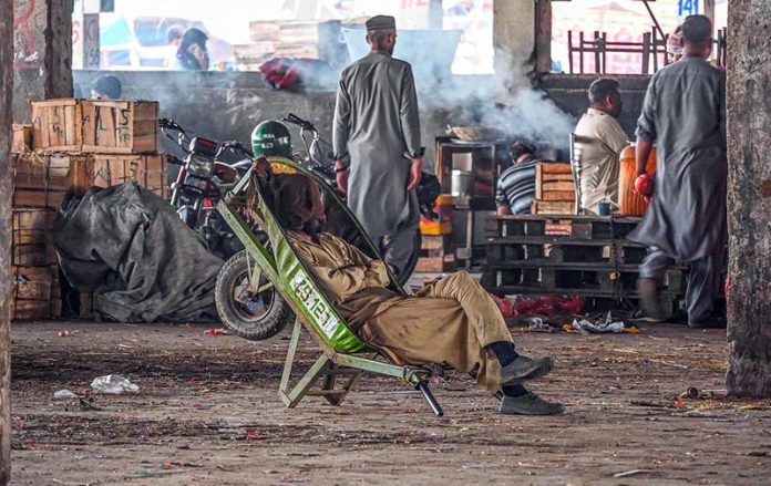 Tired laborer takes a nap after a hard day in Islamabad’s vegetable market