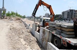 Laborer’s busy making roadside boundary wall at the site of under construction 10th Avenue during development work in Federal Capital