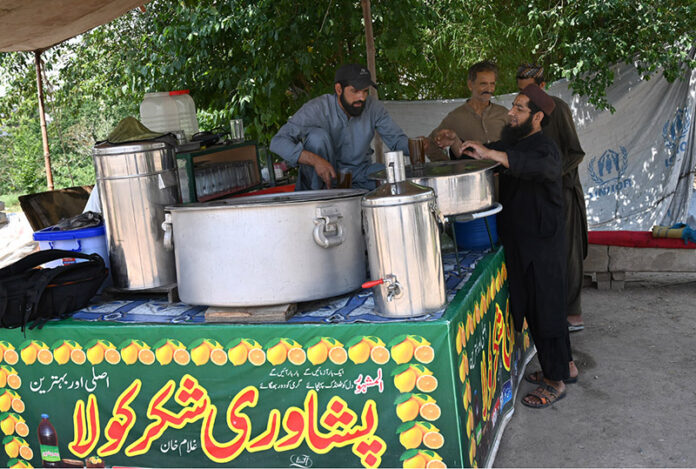 A vendor selling traditional summer drink (Shakar Cola) at his roadside setup
