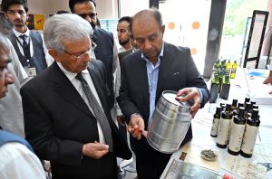 Federal Minister for National Food Security and Research, Rana Tanveer Hussain inspects an olive products stall during the workshop on "Innovating the Olive Value Chain: Startups, Entrepreneurship & Opportunities", organized under Phase-II of the Promotion of Olive Cultivation on Commercial Scale project by the Ministry of National Food Security & Research at SZABIST