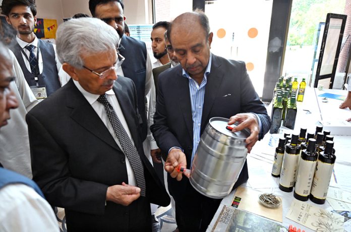 Federal Minister for National Food Security and Research, Rana Tanveer Hussain inspects an olive products stall during the workshop on 