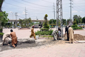 IESCO workers are busy installing electricity pole near IJP Road in the Federal. Capital