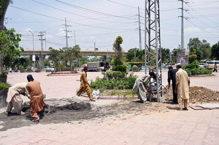 IESCO workers are busy installing electricity pole near IJP Road in the Federal. Capital