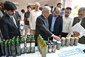 Federal Minister for National Food Security and Research, Rana Tanveer Hussain inspects an olive products stall during the workshop on "Innovating the Olive Value Chain: Startups, Entrepreneurship & Opportunities", organized under Phase-II of the Promotion of Olive Cultivation on Commercial Scale project by the Ministry of National Food Security & Research at SZABIST