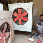 An electrician fixes a room cooler as demand rises with the arrival of summer in the city