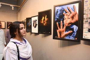 A student keenly observes a display at the “Photojournalism in the Digital Era” exhibition organized by the Mask Communication Department of the University of Sargodha