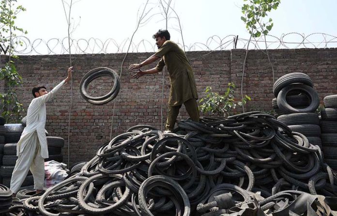 Laborers busy in their work at scrap tires gudon at Ring road