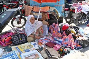 People purchasing fruits from a stall at weekly Sunday Bazaar, Peshawar Morr in Federal Capital.