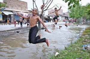 Youngster jumping and bathing in canal at Fazil Town to get some relief from scorching hot weather in the city.