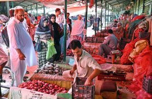 People purchasing fruits from a stall at weekly Sunday Bazaar, Peshawar Morr in Federal Capital.