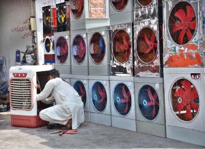 A shopkeeper prepares room coolers for sale at his workplace, as temperatures is increasing day by day in the city