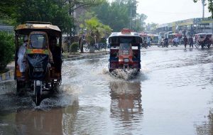 Vehicles passing through rain water accumulated on road at GTS Chowk
