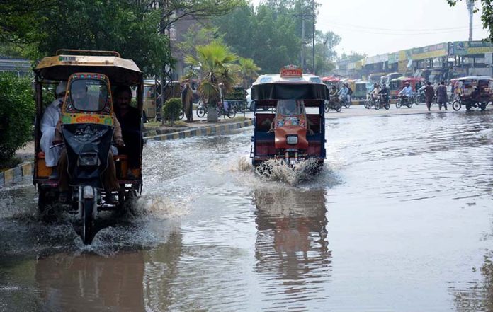 Vehicles passing through rain water accumulated on road at GTS Chowk