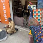 A craftsman makes beautiful models of peacocks at his workplace in the federal capital