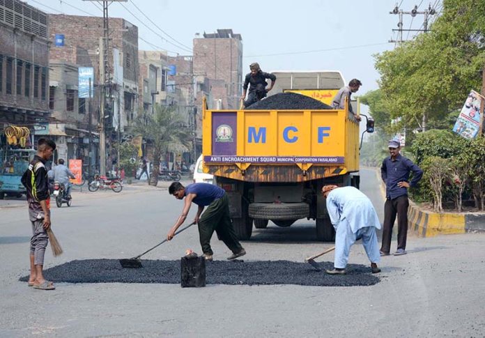 Labourers engaged in road repair work to ensure smooth traffic flow, as part of ongoing development projects in the city