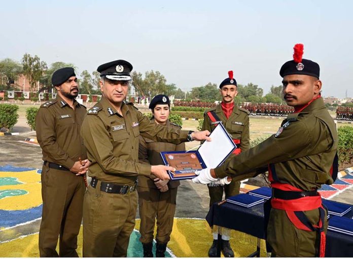 RPO Sargodha Muhammad Shahzad Asif Khan and Dr. Anam Faryal Afzal, Principal of Police Training School Sargodha, giving away an award to a top-performing trainee during the passing out ceremony of the 94th Basic Recruit Course