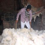 A worker is busy preparing cotton for filling quilts at his workplace