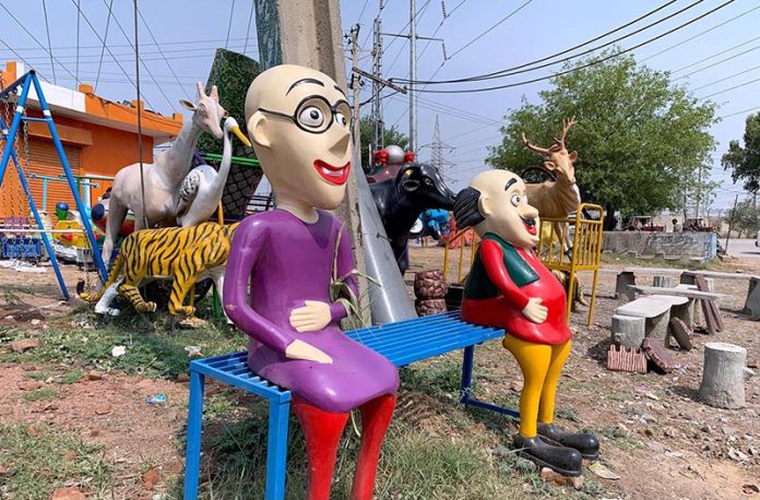 Fiber statues of famous cartoon characters Motu Patlu displayed for sale on the roadside in the federal capital