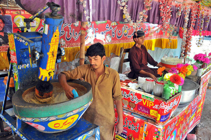 A vendor is busy preparing traditional summer drink (Ghota) for the customers at his roadside setup