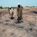 Workers engaged in construction brick-making at a local kiln as part of their daily labor