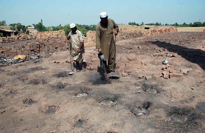 Workers engaged in construction brick-making at a local kiln as part of their daily labor
