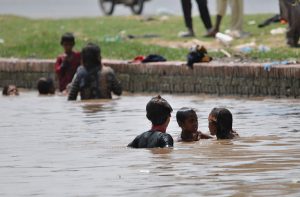 Family enjoy bathing in a local canal during scorching hot weather.