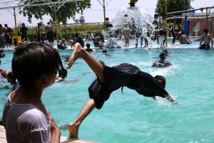 Youngsters bathing in a swimming pool to get relief from scorching hot weather in City.