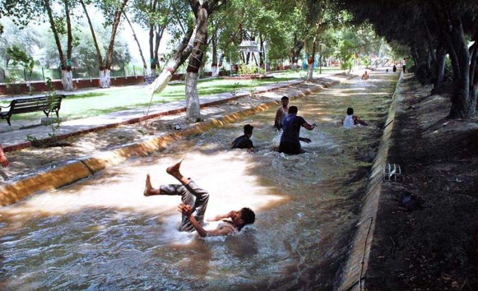 Children and young people are taking a dip in the canal water to escape the intense heat