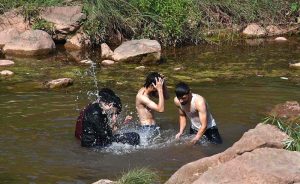 People cool off in the stream at Angoori Dam to escape the sweltering heat in the federal capital