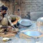 A worker busy in roasting grams for customers at his workplace