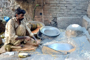 A worker busy in roasting grams for customers at his workplace