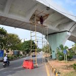 Workers busy painting work on Peshawar Mor interchange in the Federal Capital