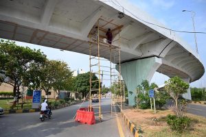 Workers busy painting work on Peshawar Mor interchange in the Federal Capital