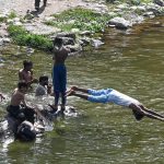 A youngster dives into the Korang Nullah near Rawal Dam to swim and cool off during warm weather in the federal capital