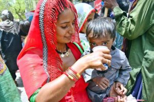 A woman gives her child summer drink at a heatstroke relief camp during hot weather in the city