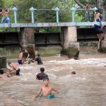 To escape the heat and humidity, people dive, swim, and bathe in the Lahore Canal, seeking relief from the sweltering weather in the city