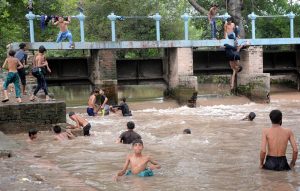 To escape the heat and humidity, people dive, swim, and bathe in the Lahore Canal, seeking relief from the sweltering weather in the city
