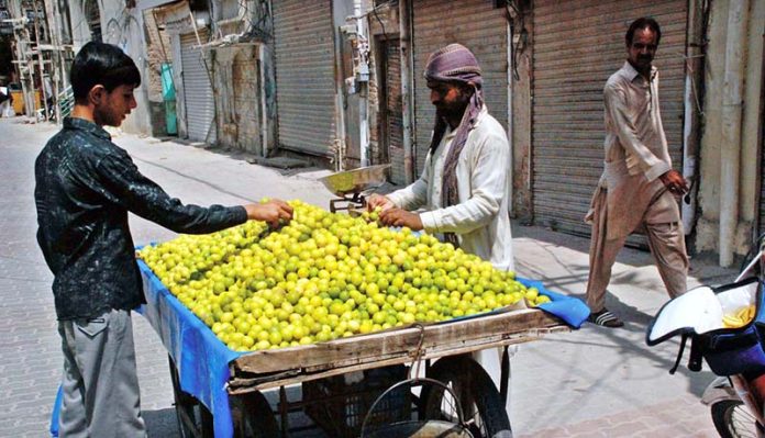A man is selling lemons on the road side
