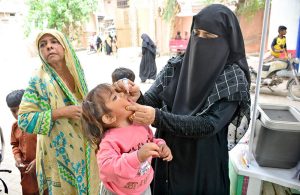 A lady health worker administers polio drops to a child during the ongoing anti-polio campaign aimed at eradicating the disease from Pakistan