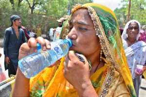 A woman gives her child summer drink at a heatstroke relief camp during hot weather in the city
