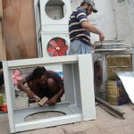 Workers assemble water air coolers to beat the intense heat, as demand surges in the city due to the scorching weather